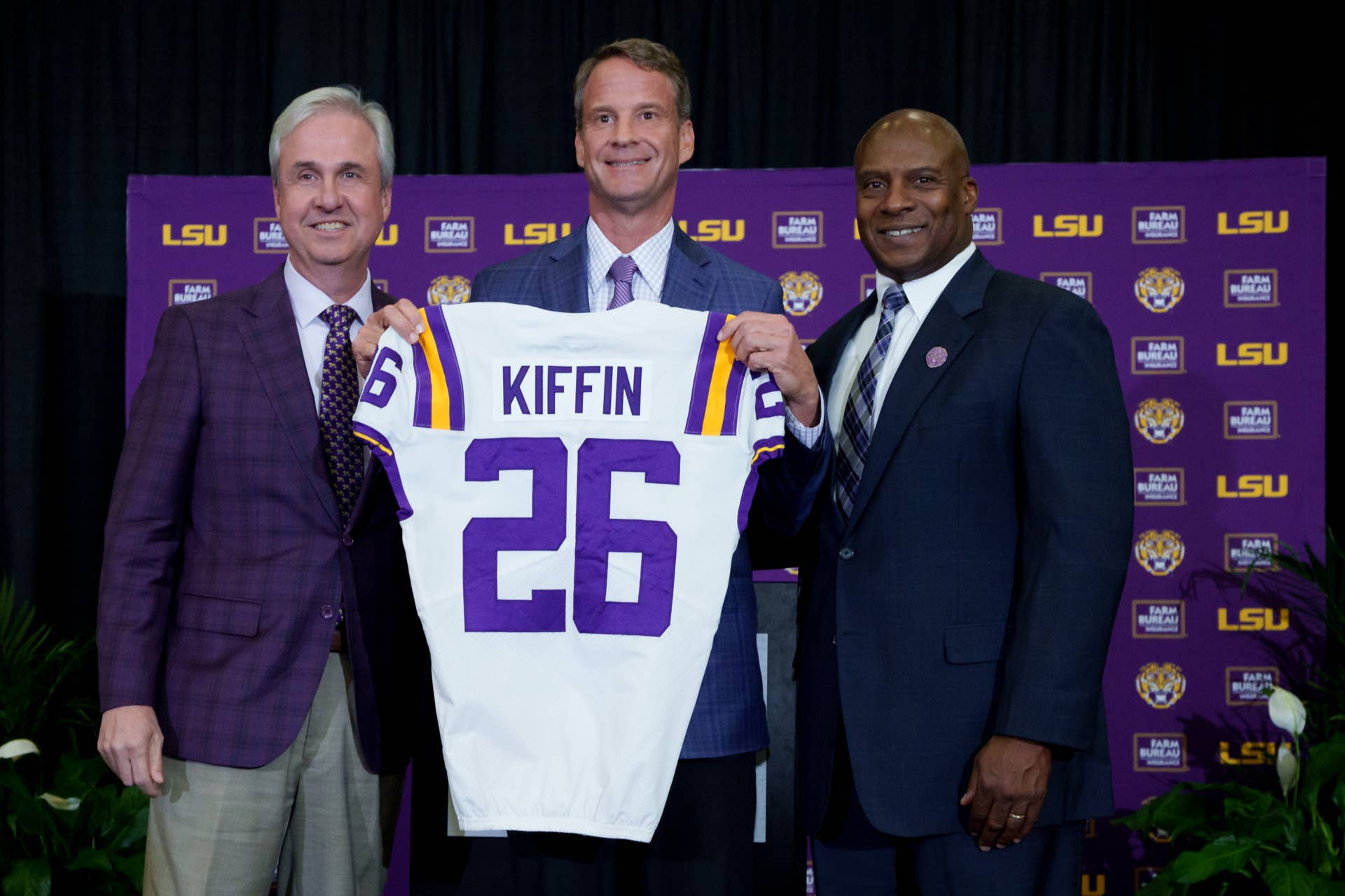 Lane Kiffin introduced as LSU head football coach alongside university leadership holding a Kiffin 26 jersey
