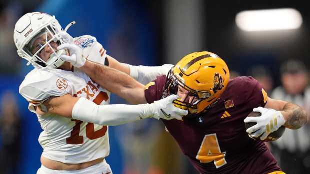 Jan 1, 2025; Atlanta, GA, USA; Arizona State Sun Devils running back Cam Skattebo (4) and Texas Longhorns defensive back Michael Taaffe (16) push each other during the second half of the Peach Bowl at Mercedes-Benz Stadium. Mandatory Credit: Dale Zanine-Imagn Images