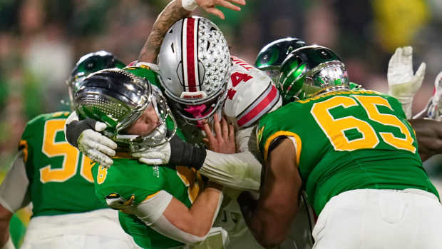 Ohio State defensive end JT Tuimoloau (44) hits Oregon quarterback Dillon Gabriel during the second half of the College Football Playoff quarterfinal at the Rose Bowl in Pasadena, Calif. on Jan. 1, 2025.