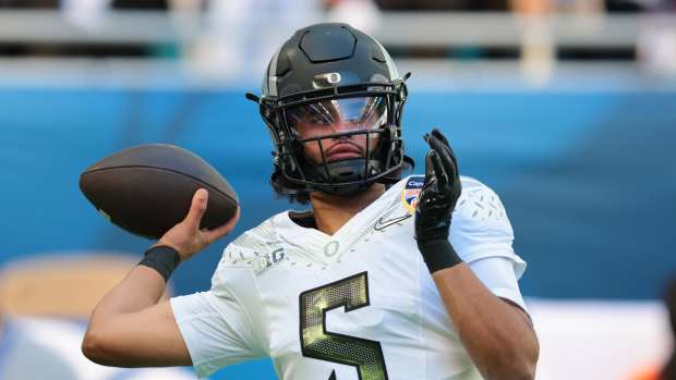 Jan 1, 2026; Miami Gardens, FL, USA; Oregon Ducks quarterback Dante Moore (5) warms up prior to the 2025 Orange Bowl and quarterfinal game of the College Football Playoff against the Texas Tech Red Raiders at Hard Rock Stadium. Mandatory Credit: Sam Navarro-Imagn Images