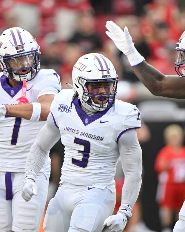 Sep 5, 2025; Louisville, Kentucky, USA; James Madison Dukes linebacker Gannon Weathersby (3) celebrates with safety Jacob Thomas (7) and defensive lineman Xavier Holmes (9) during the first half against the Louisville Cardinals at L&N Federal Credit Union Stadium. Mandatory Credit: Jamie Rhodes-Imagn Images